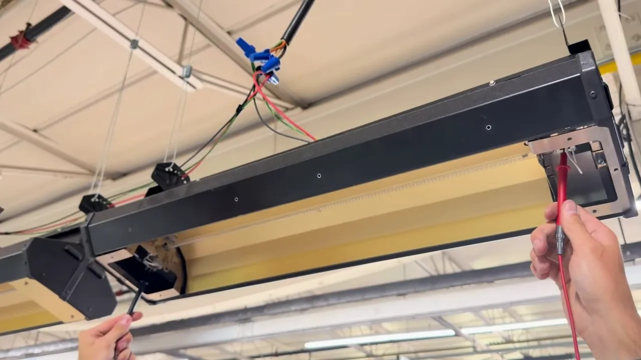 Multimeter probes held at the exposed connections on both ends of an electric heater