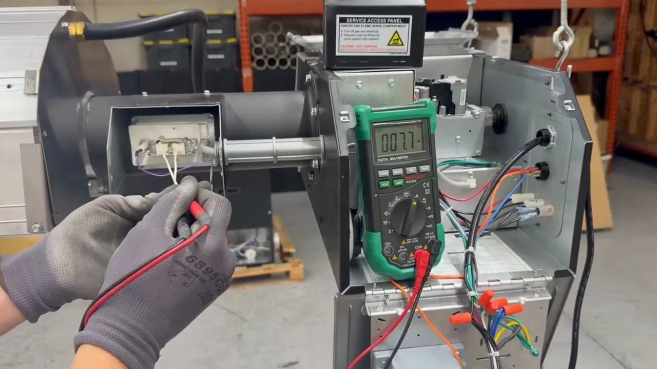 Multimeter connected to a glow bar connector during resistance test